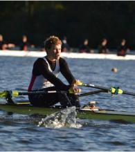 Oskar Sødal fra Kristiansand Roklubb ror på vann i en singlesculler